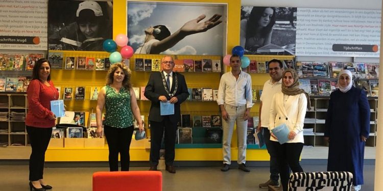 Burgemeester neemt boekje Taalpuntcursisten in ontvangst gemeente 